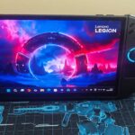 A portable laptop sits on a mat with machine designs